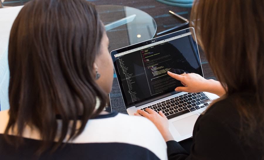 Two women going through source code together